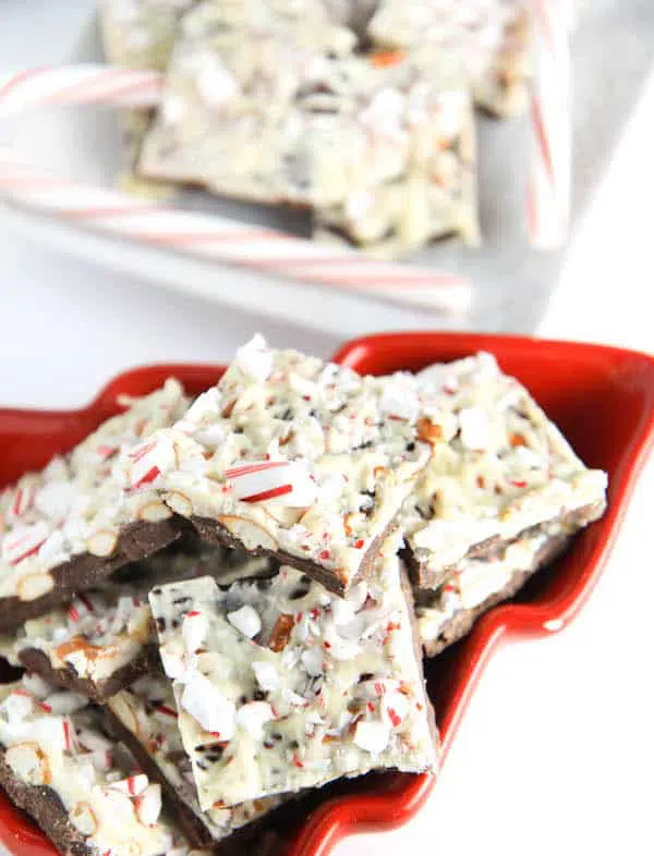 Peppermint Pretzel Bark ready and served in a red bowl in the shape of a Christmas tree.