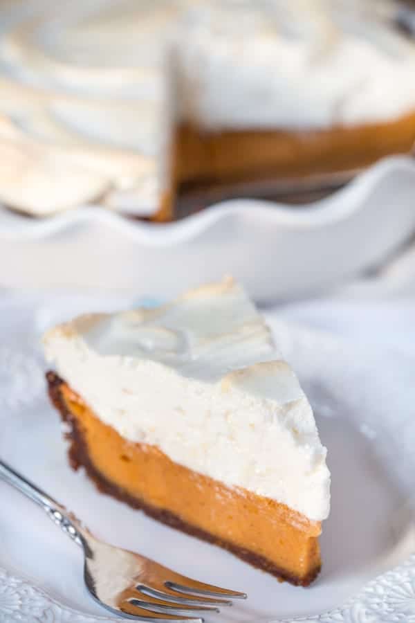 A piece of Sweet Potato Pie with Bourbon Meringue in focus with the rest of the cake blurred in the background