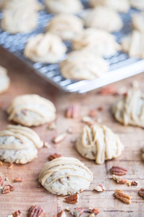 Focus on a couple of Butter Pecan Maple Cookies with lots of other cookies blurred in the background