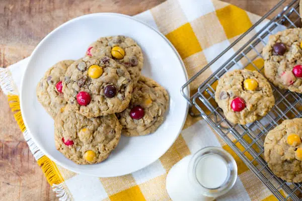 Peanut Butter M&M Oatmeal Cookies served with milk and decorated with a yellow white cloth