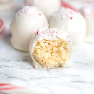 Focus on one of the White Chocolate Peppermint Oreo Truffles with more truffles blurred in the background