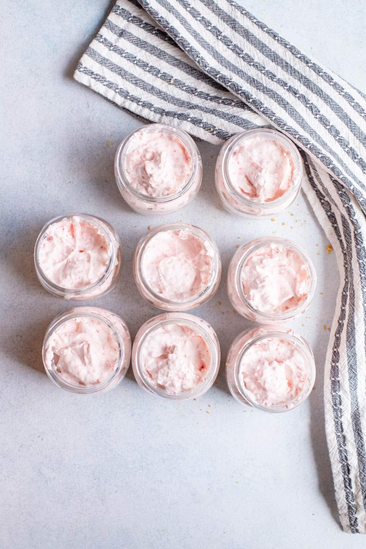 Mini mason jars with strawberry cheesecake filling in them.