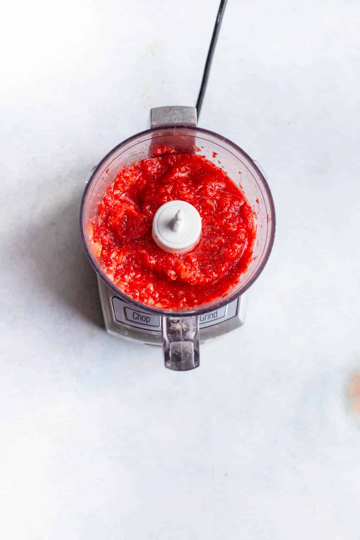 Strawberries in a food processor that have been pureed.