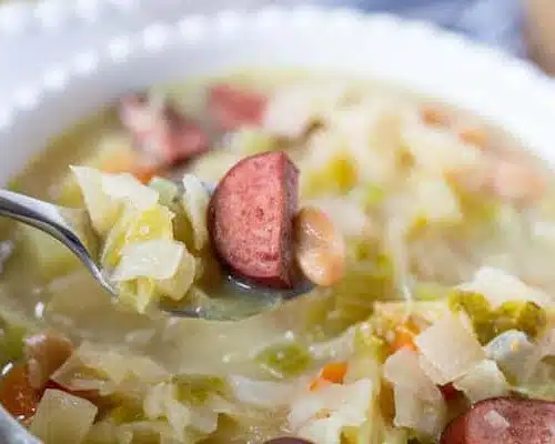 Slow Cooker Kielbasa and Cabbage Soup Closeup with a Spoon Full of the Delicious Spoon