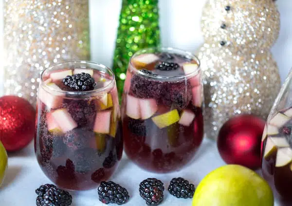 Spiced Blackberry Pear Sangria in Two Glasses with Blackberries and Toys Around