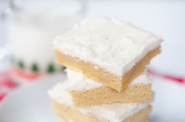 A stack of three Eggnog Sugar Cookie Bars in the center of the frame looking delicious