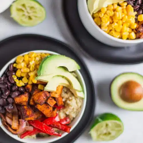 Vegetarian Quinoa Burrito Bowls with Avocado Cream Sauce - Exquisite Recipe with the Ingredients Blurred in the Background