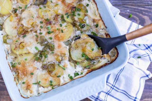 Leek and Gruyere Scalloped Potatoes on the Table with a Spoon Full of the Yummy Potatoes