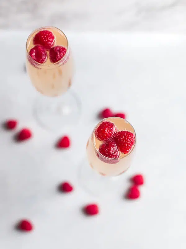 Raspberry Mimosas - Overhead Shot of Two Glasses with Raspberries Inside