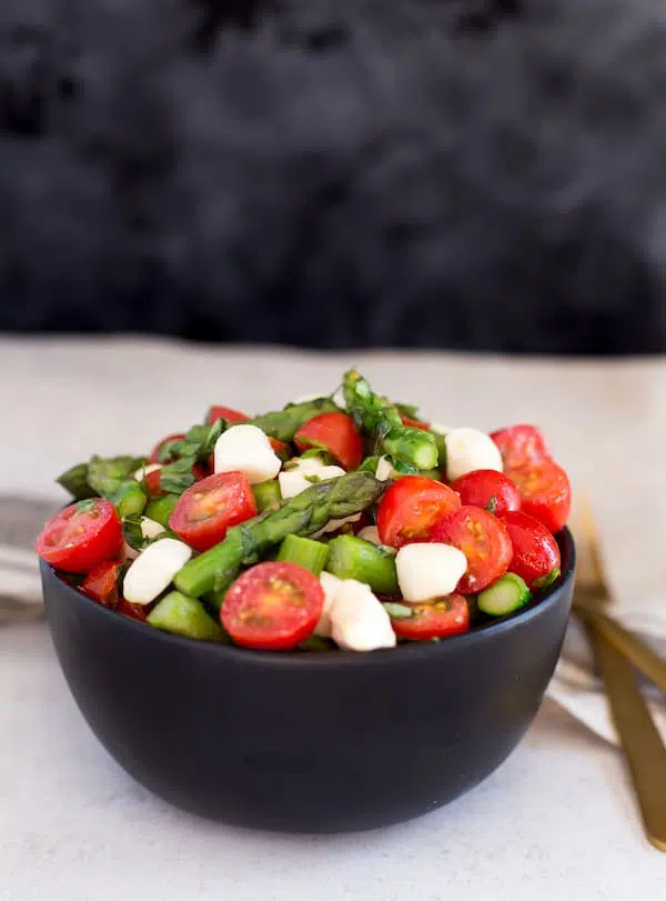 Asparagus Caprese Salad Beautiful Shot with a Dark Background and a Light Table