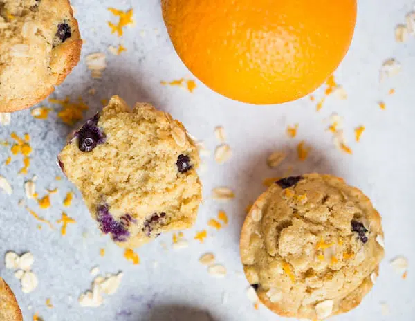 Blueberry Orange Oat Muffins Overhead on the Muffins and a Big Orange