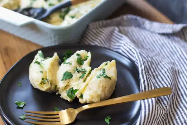 Creamy Garlic and Herb Chicken Stuffed Shells with One Metal Fork Inside the Plate