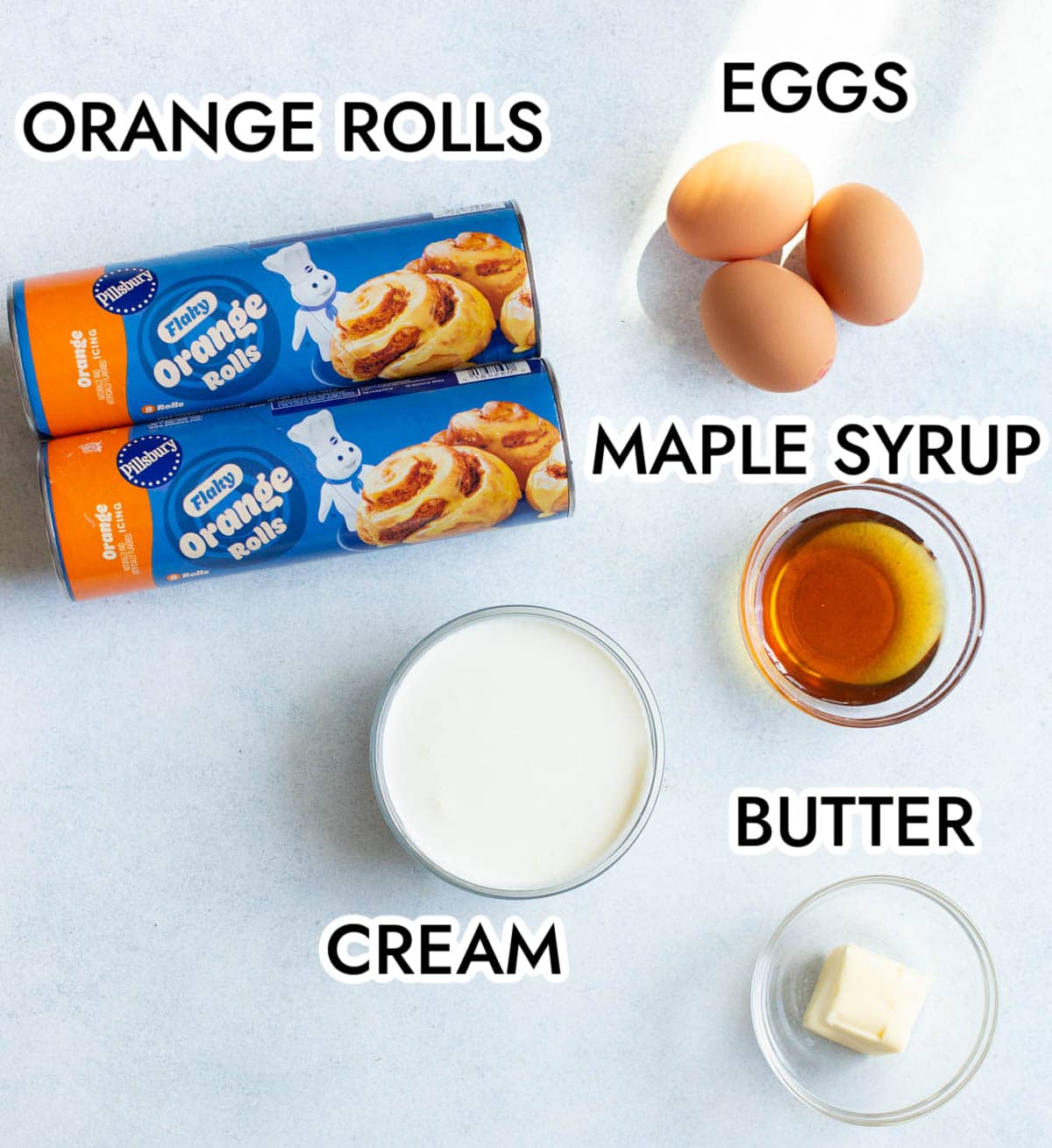 Ingredients in Orange Roll Casserole on a gray background with black text labeling each ingredient.