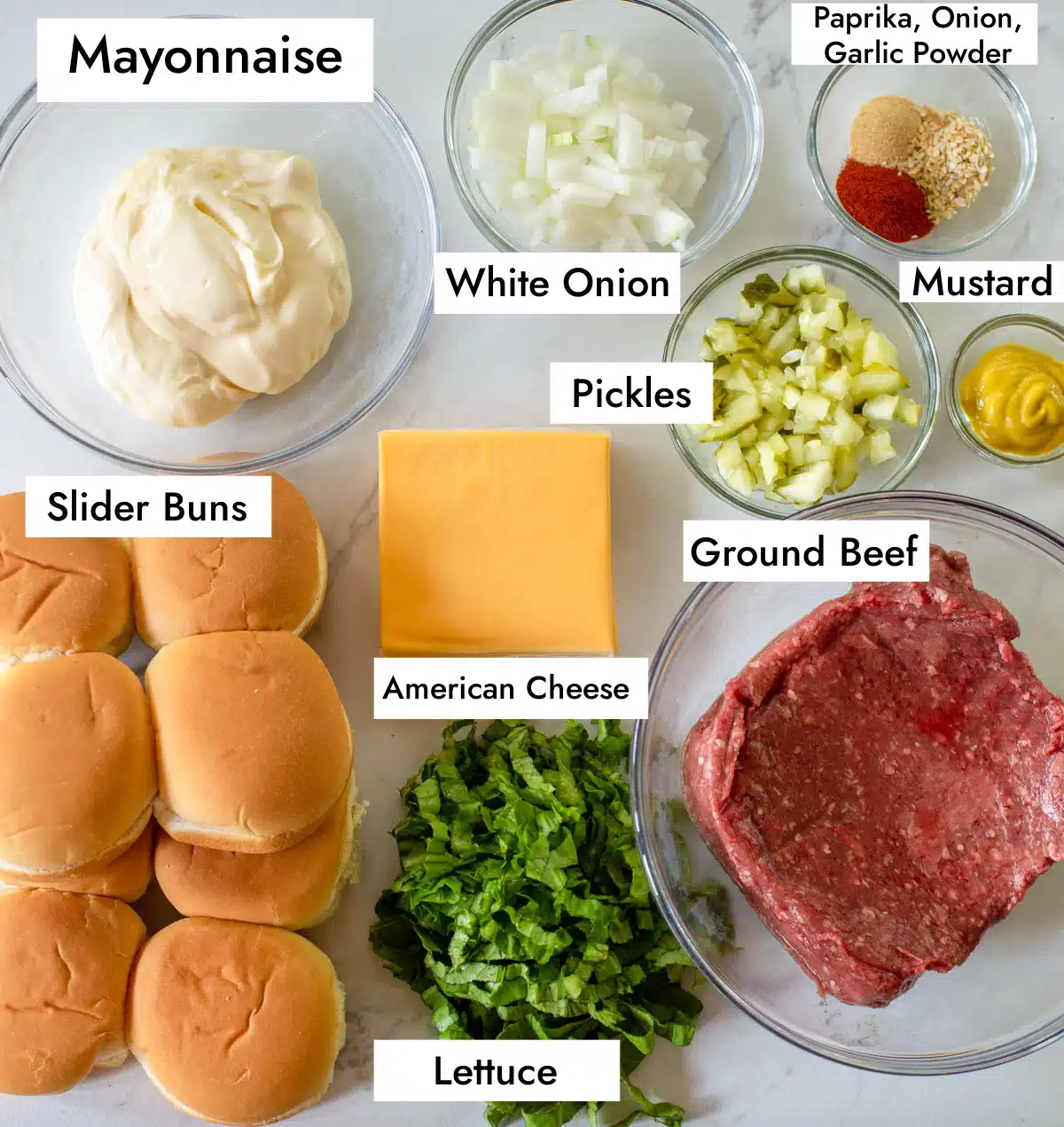Ingredients in Big Mac Sliders on white and gray marble countertop.