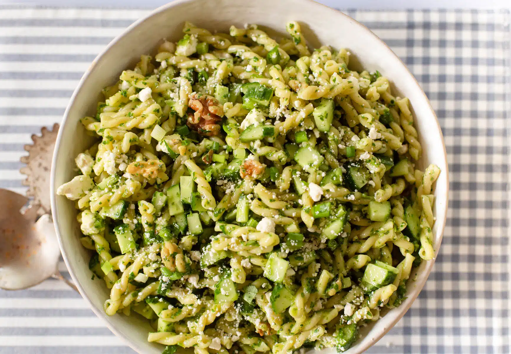 Green Goddess Pasta Salad in a bowl with serving spoons. 