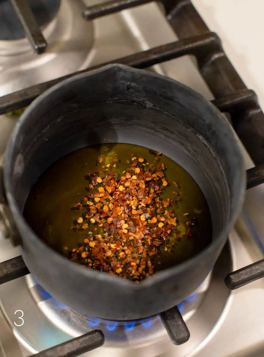 Honey and red pepper flakes in a small saucepan on the stovetop.