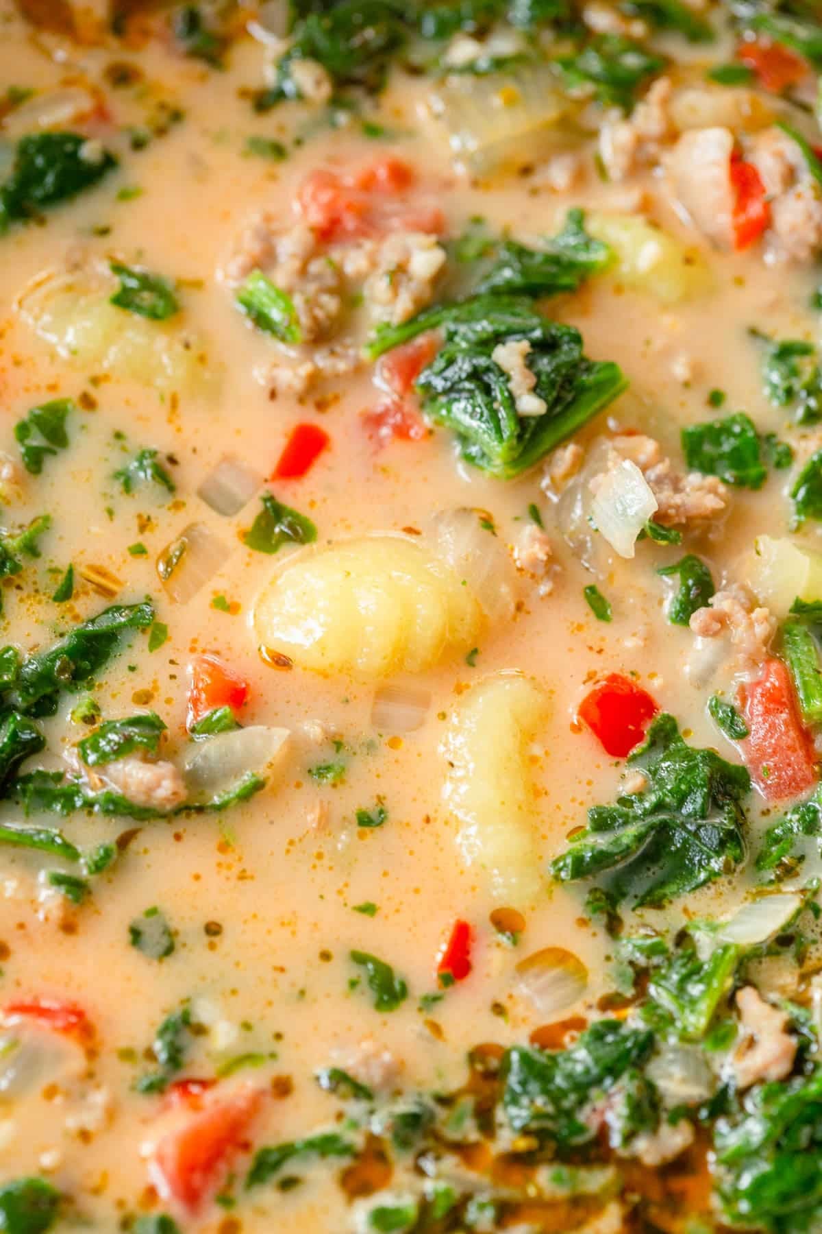 Italian Sausage Gnocchi Soup with a creamy broth, red peppers, spinach, gnocchi, and sausage.
