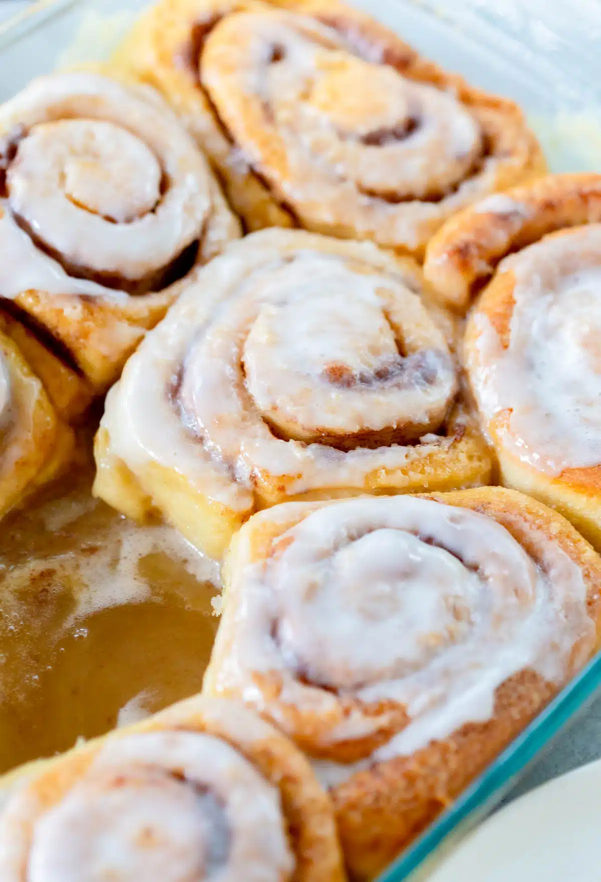 TikTok Cinnamon Rolls in a pan with buttery brown sugar sauce on the bottom of the pan. 