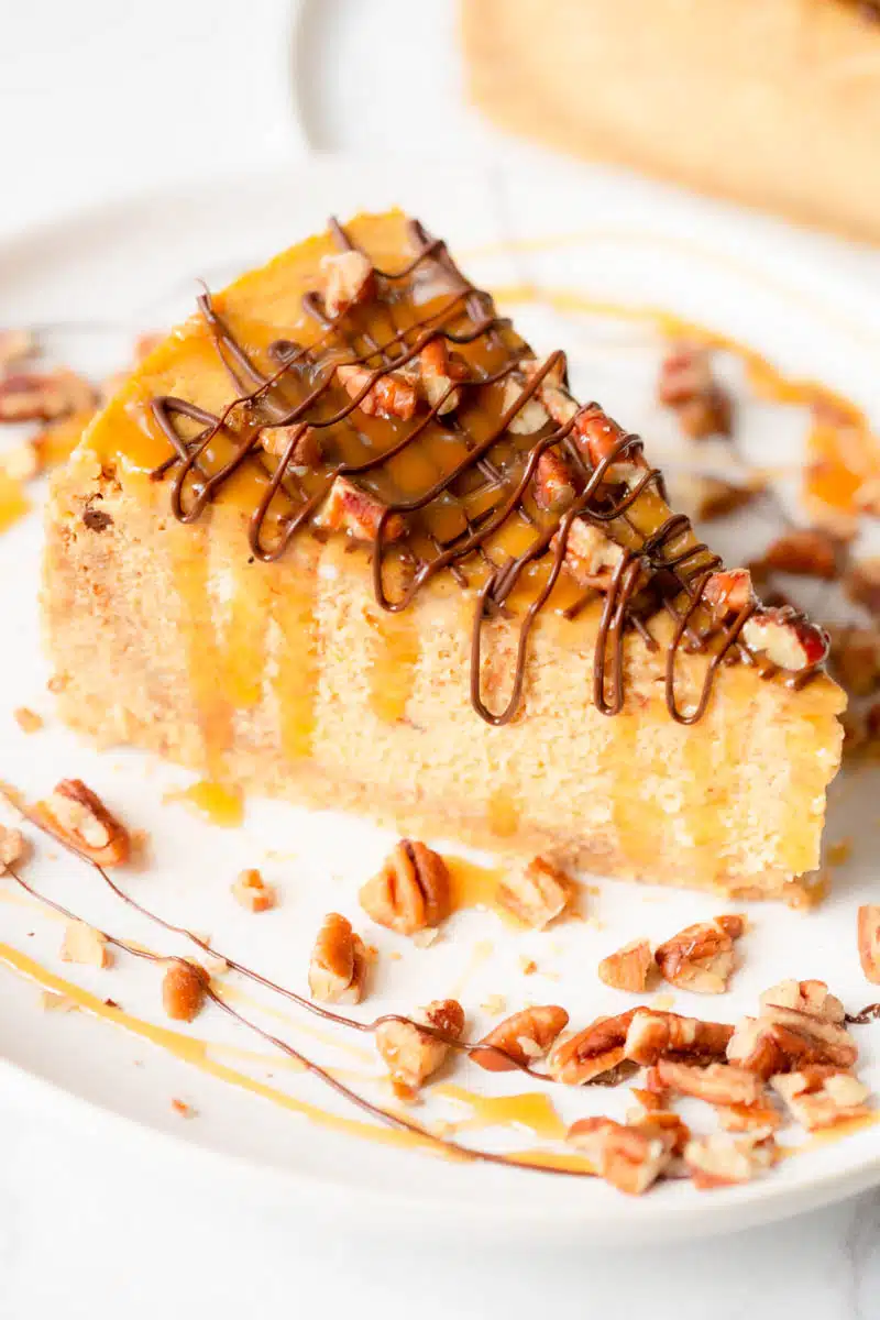 Turtle Pumpkin Cheesecake drizzled with chocolate and caramel and topped with chopped pecans. 