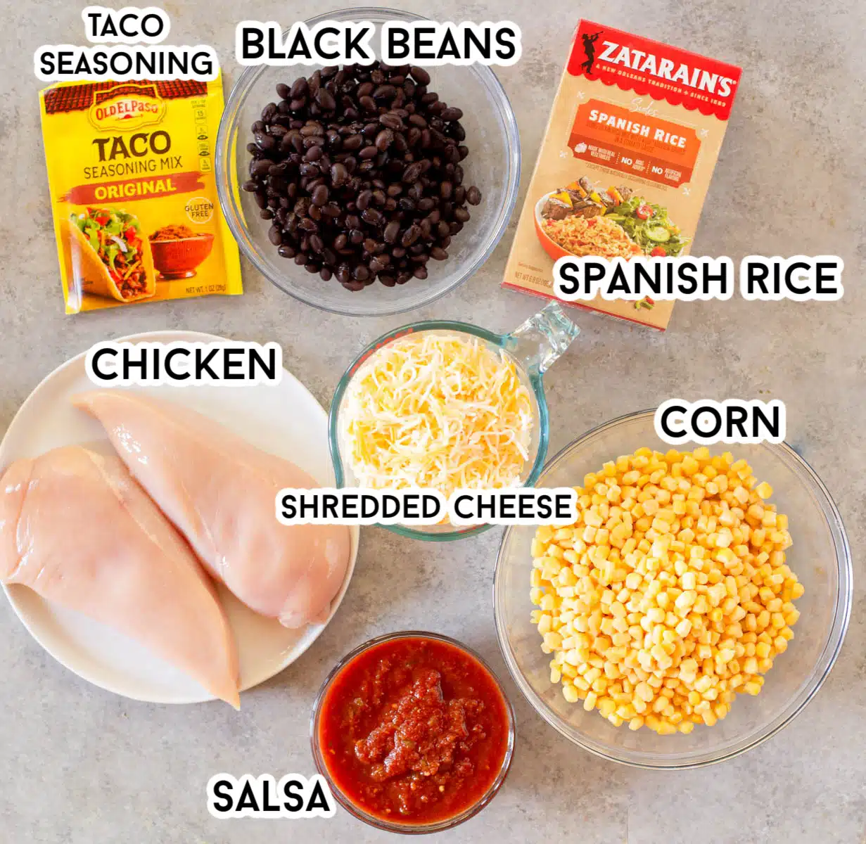 Ingredients in Chicken Taco Casserole including taco seasoning, black beans, chicken breasts, Spanish rice, shredded cheese, corn, and salsa 