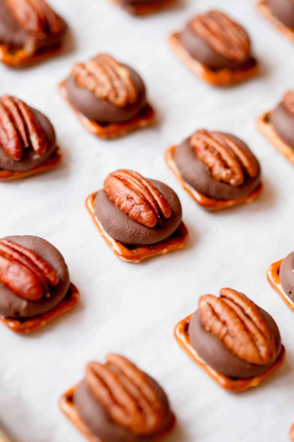 Rolo Pretzel Turtles on a baking sheet lined with parchment paper. 