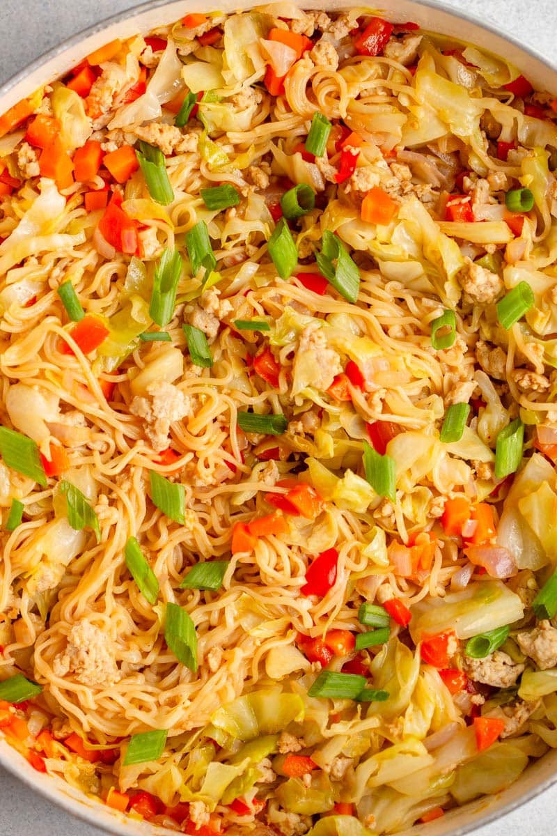 Egg Roll Noodles topped with diced green onions in a large white pan. 