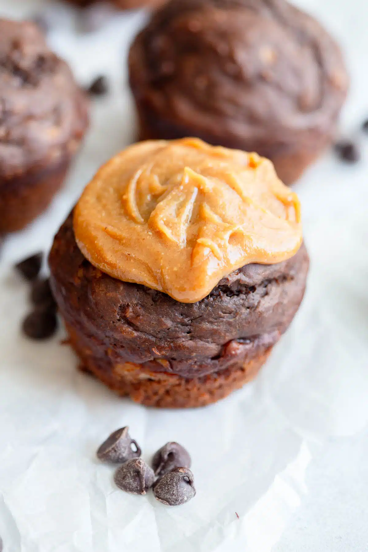 A Greek yogurt Chocolate Banana Muffin topped with a dollop of peanut butter. 
