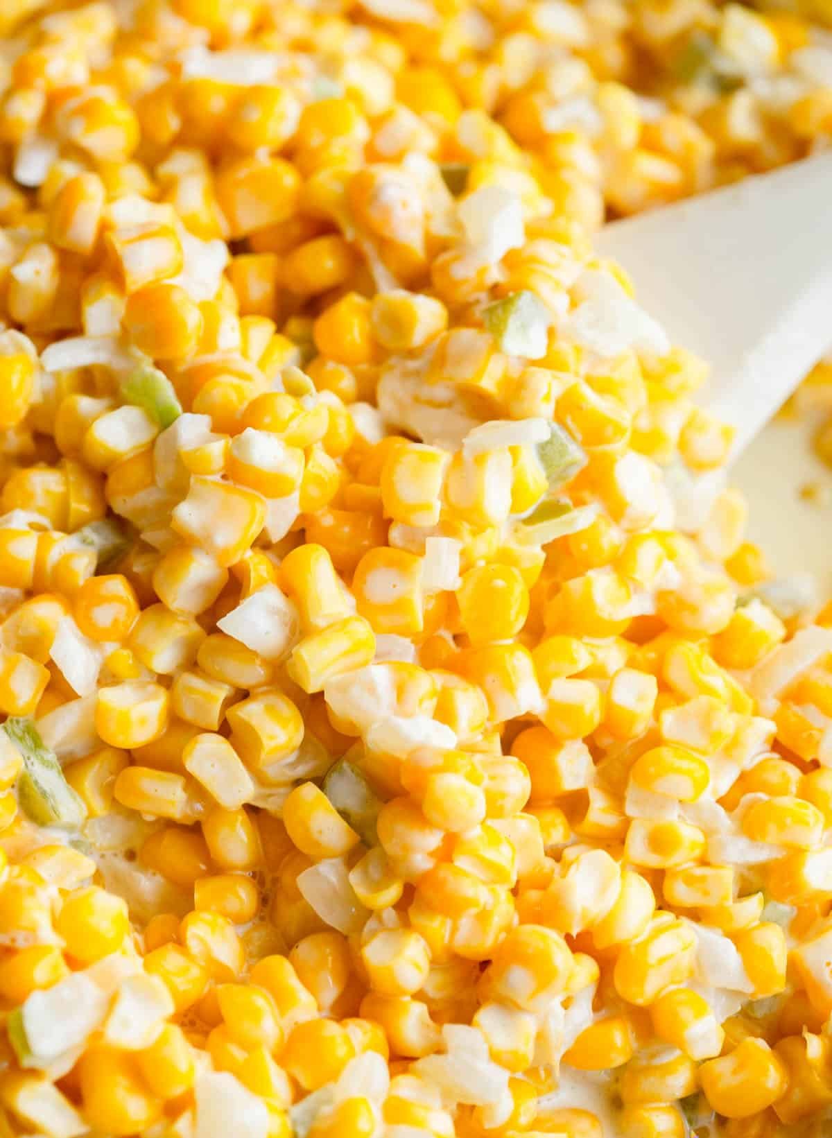 Jalapeno Creamed corn with a white spoon. 