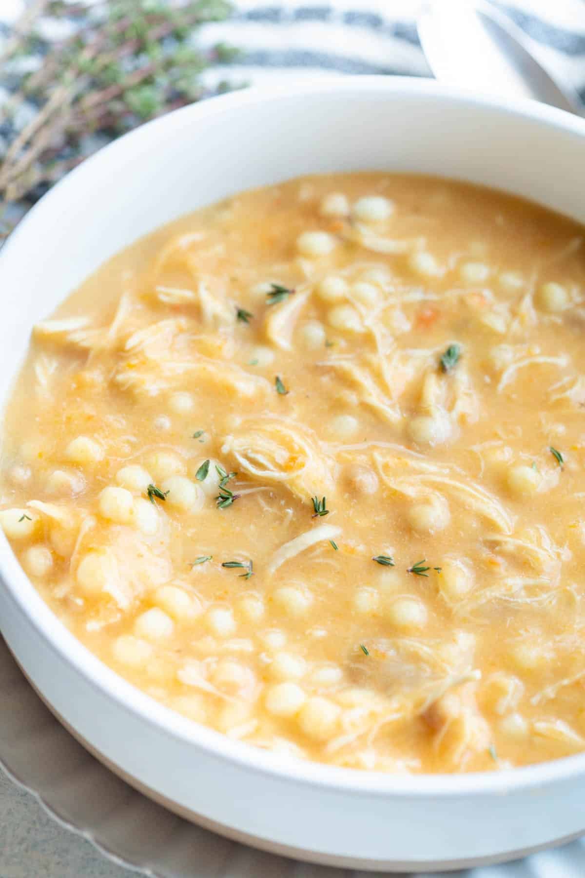 Slow Cooker Italian Penicillin Soup in a shallow bowl with fresh thyme sprinkled on top. 