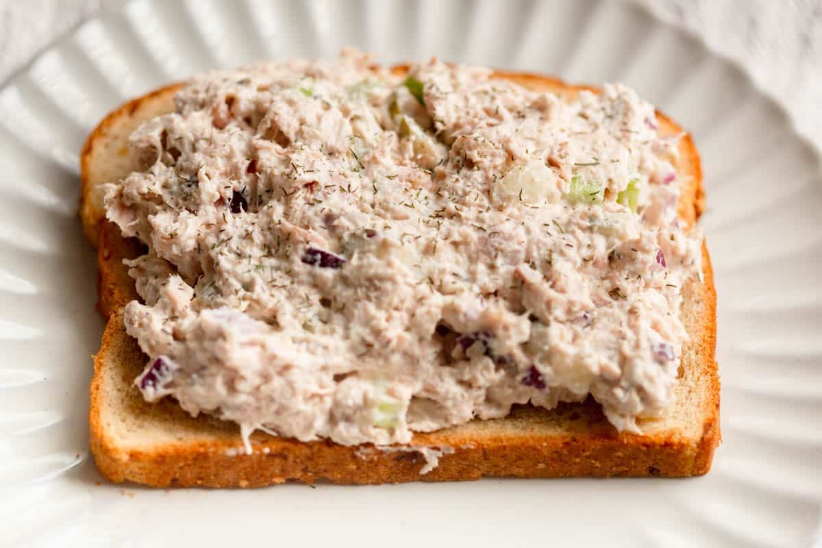 Cottage Cheese Tuan Salad on a piece of toast with dried dill sprinkled on top.