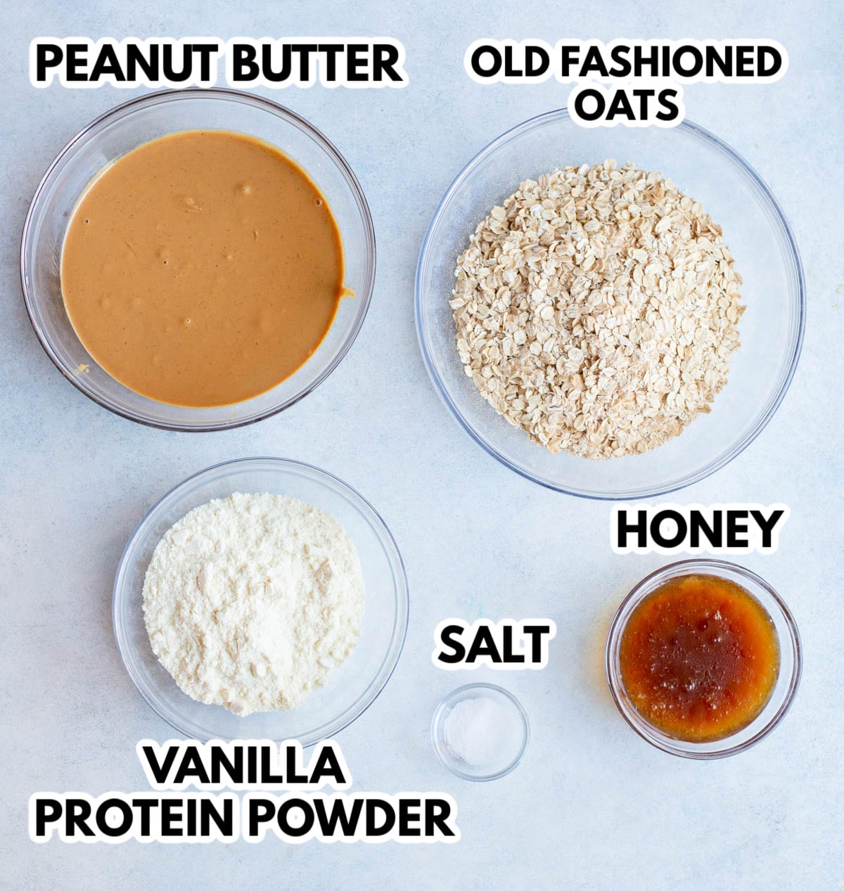 Ingredients in Peanut Butter Oat Balls on a gray background and labeled. 