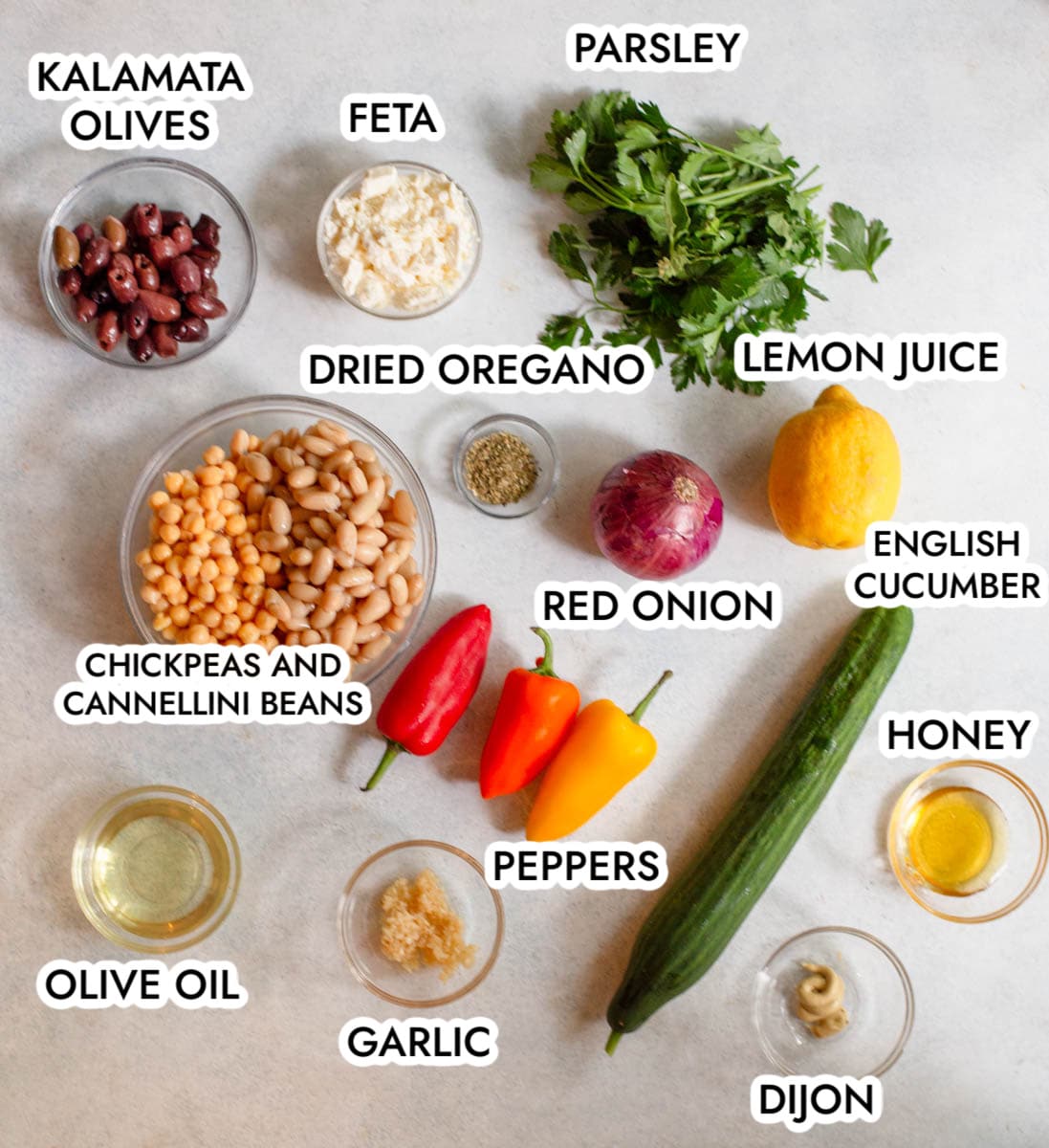 Ingredients in Greek Dense Bean Salad with a gray background.