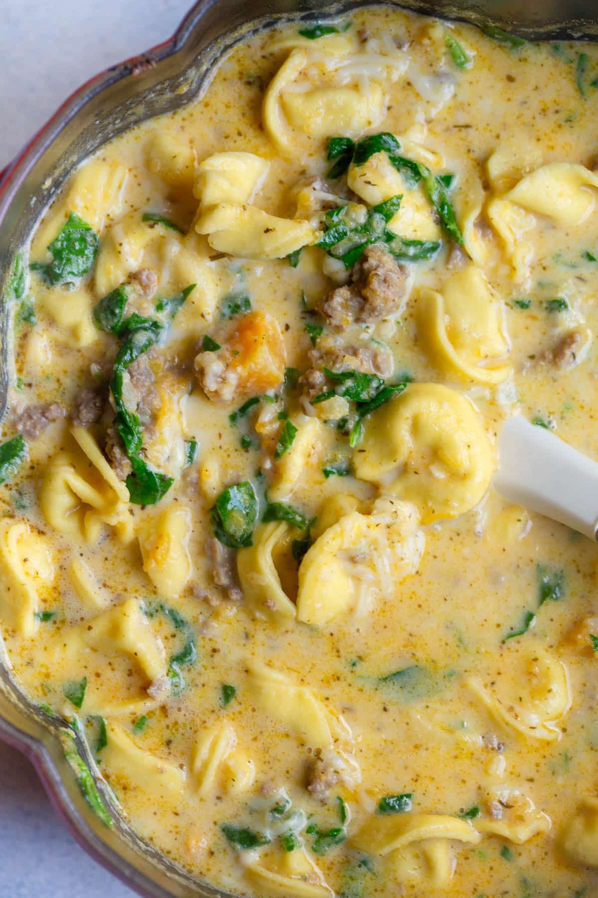 Creamy Butternut Squash and Sausage Tortellini Soup in a large soup pot shaped like a pumpkin.