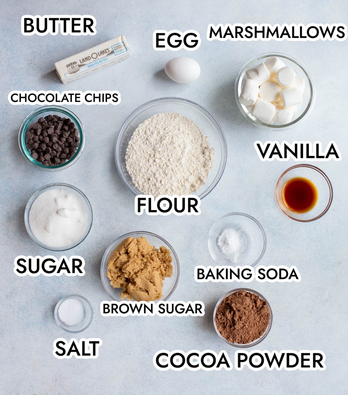 Hot Cocoa Cookies on a parchment lined baking sheet drizzled with chocolate and topped with red and green sprinkles. 