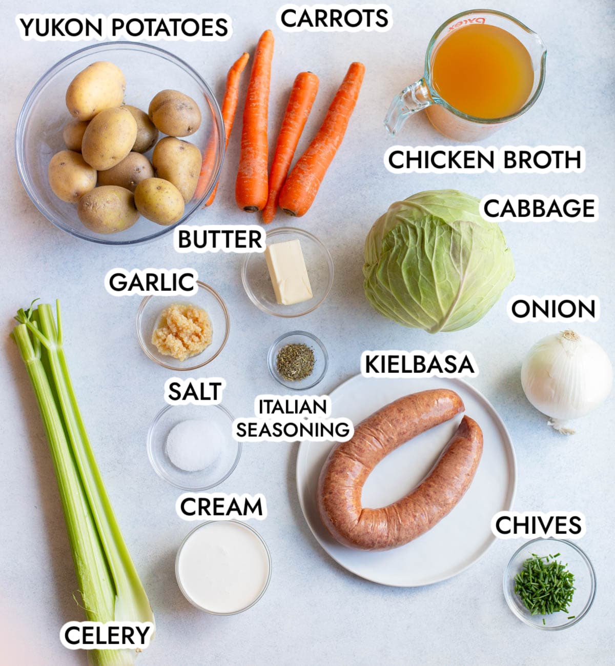 Ingredients in Creamy Kielbasa Cabbage soup with a gray background.