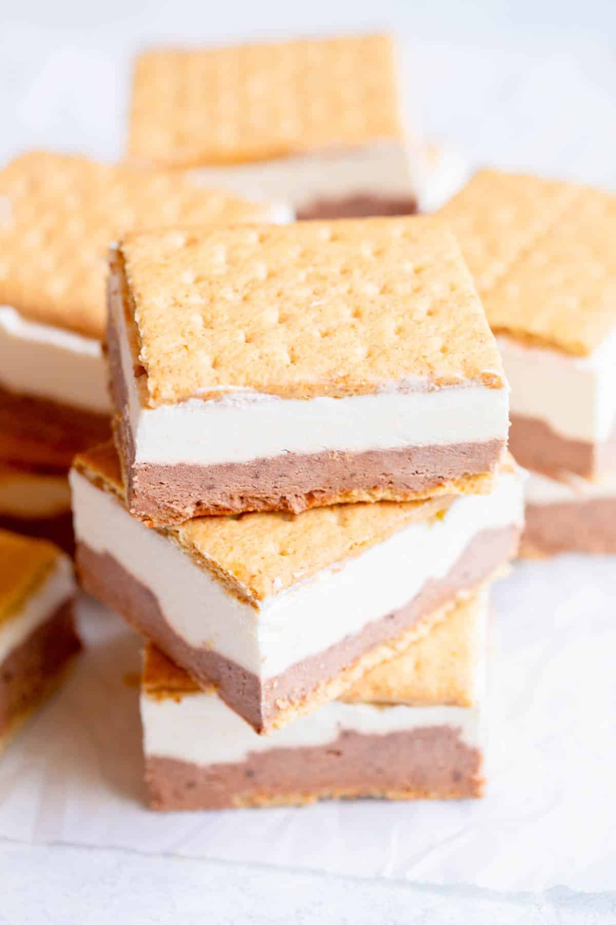 Frozen S'Mores Bars on a piece of parchment paper, stacked on top of each other.