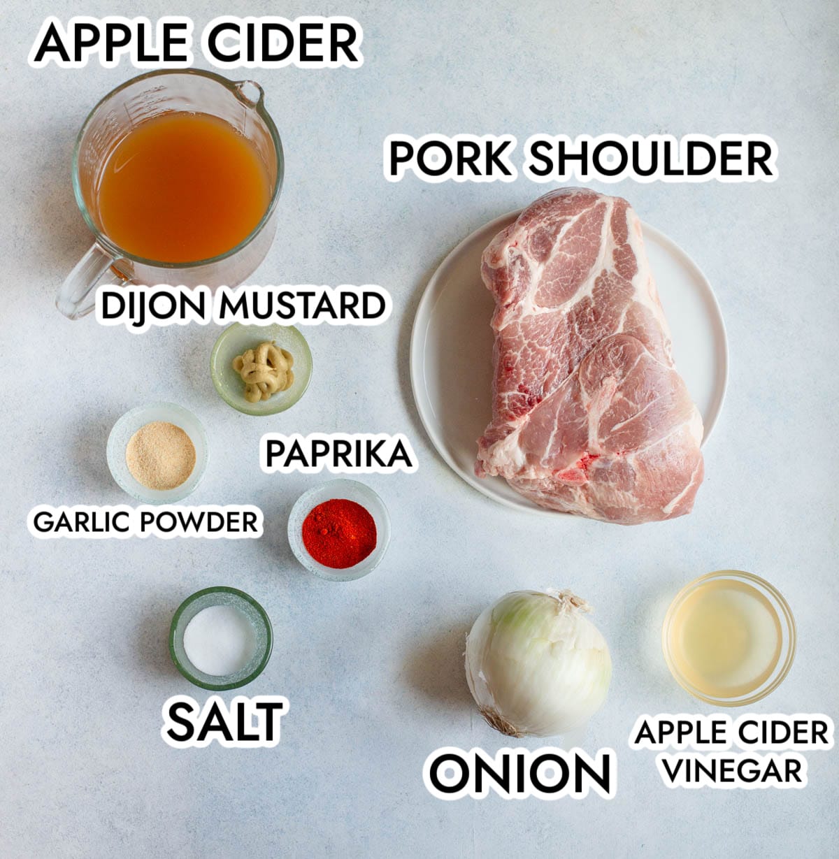 Slow Cooker Apple Cider Pulled Pork Ingredients on a gray background with black text to label each ingredient.