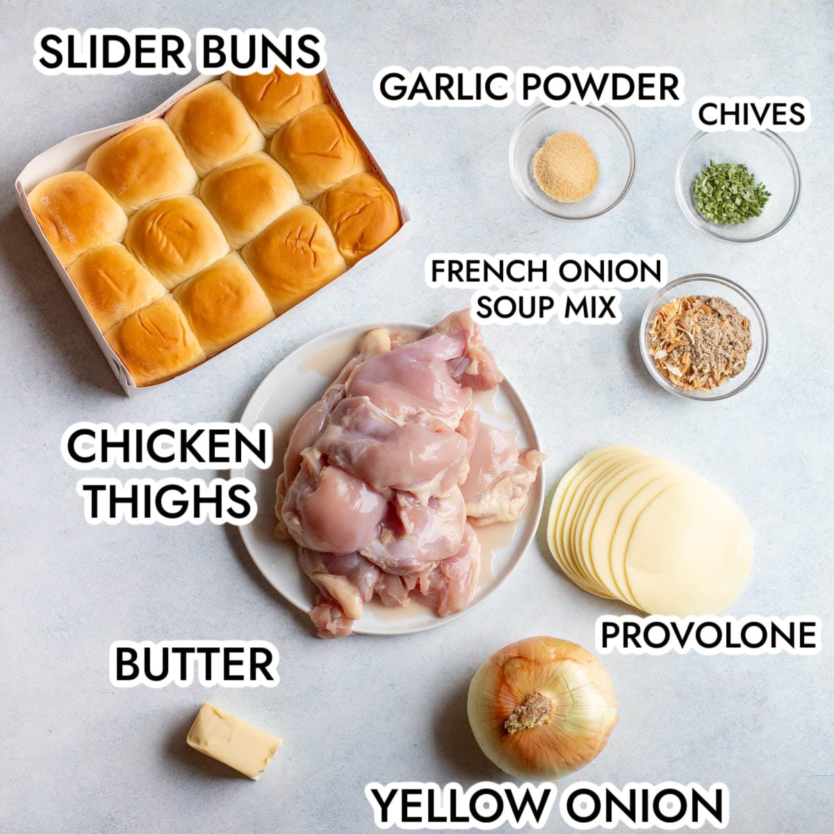 Ingredients in Slow Cooker French Onion Chicken Sliders on a gray background with black text labeling each ingredient.