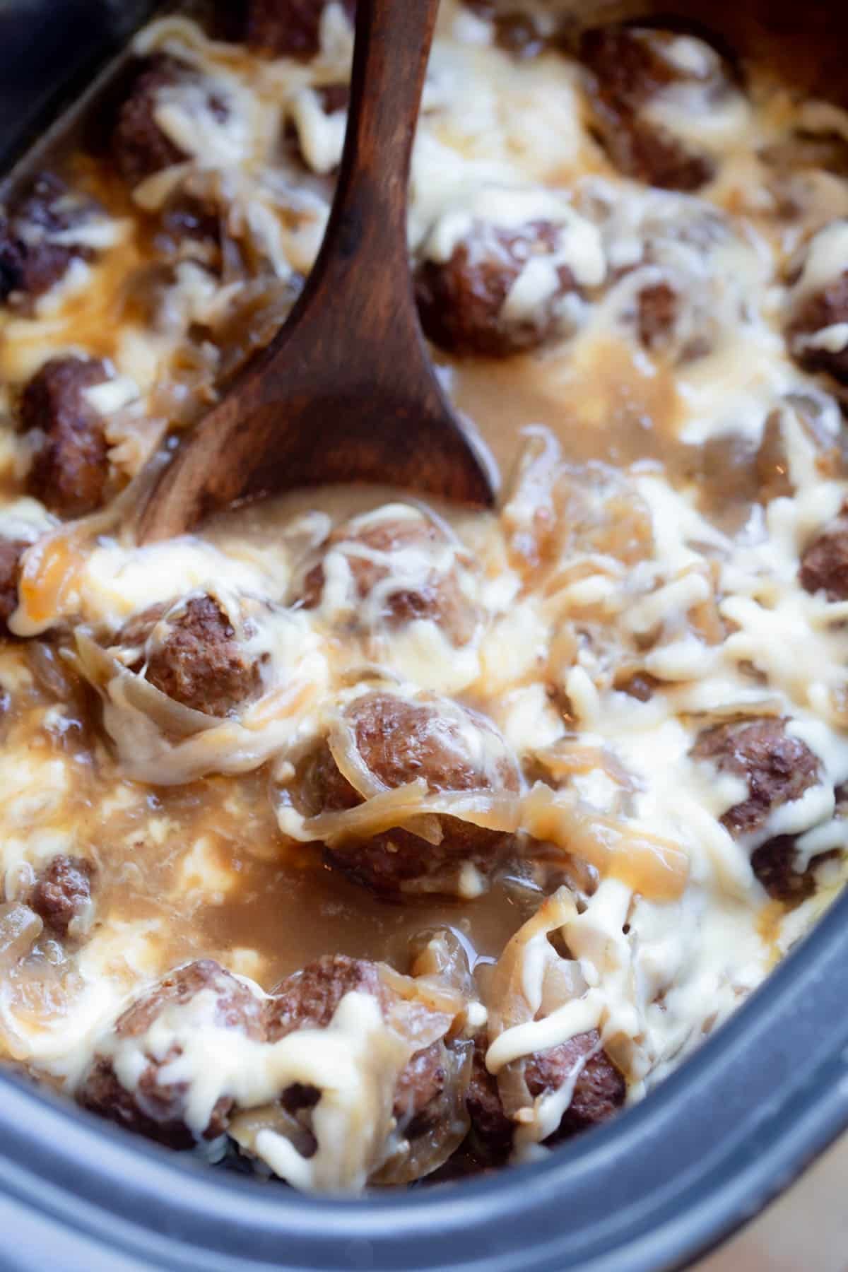 Slow Cooker French Onion Meatballs with melted shredded Gruyere on top.