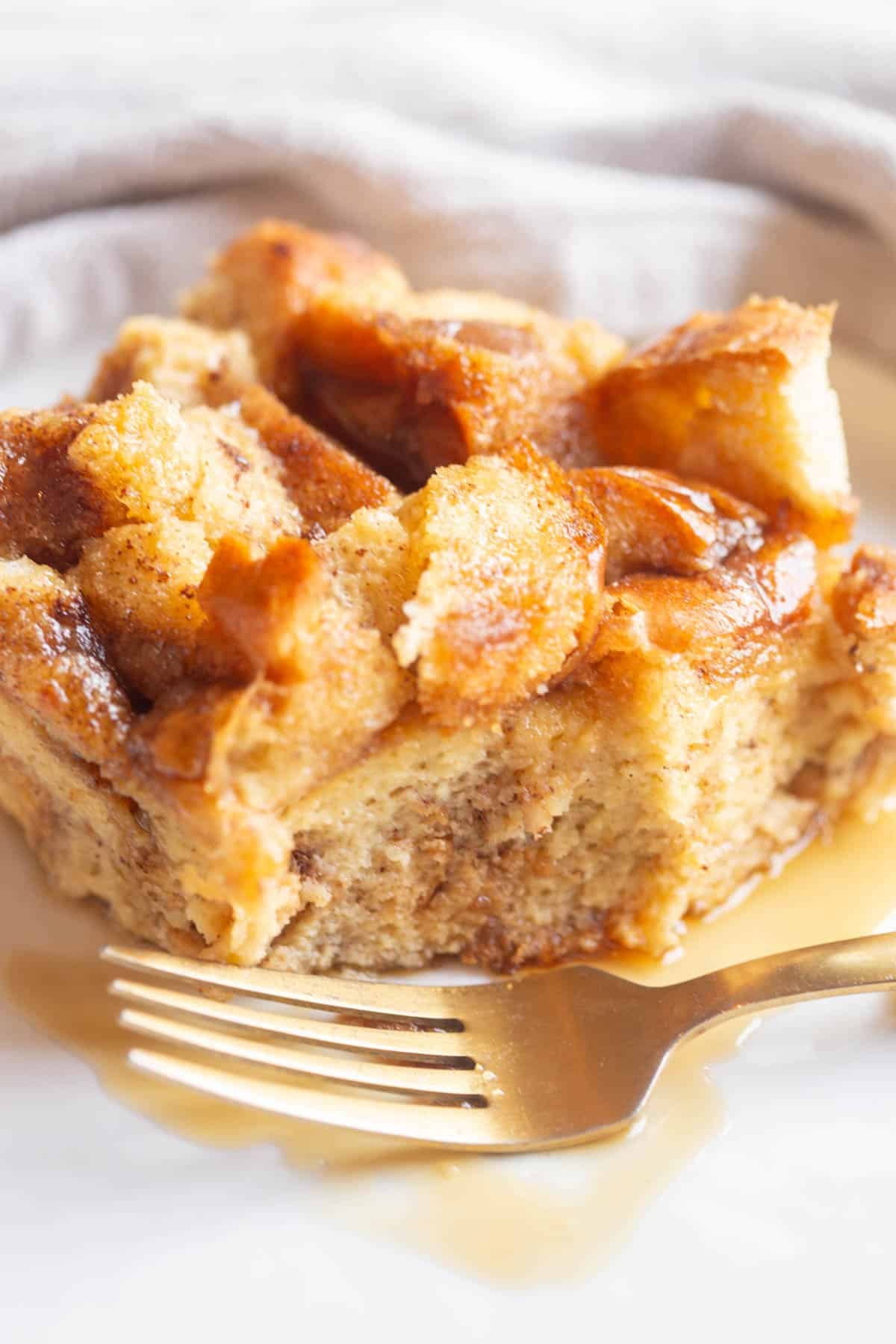 Slow Cooker French Toast Casserole with a gold fork on a white plate.